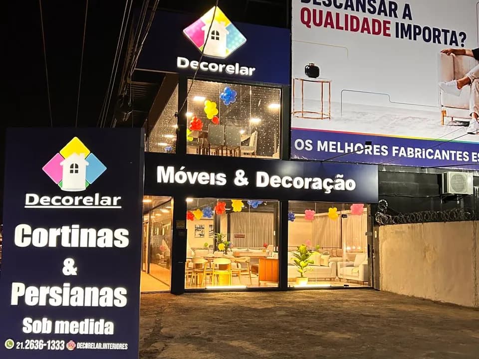 Fachada da Decorelar à noite, com o totem de cortinas e persianas sob medida