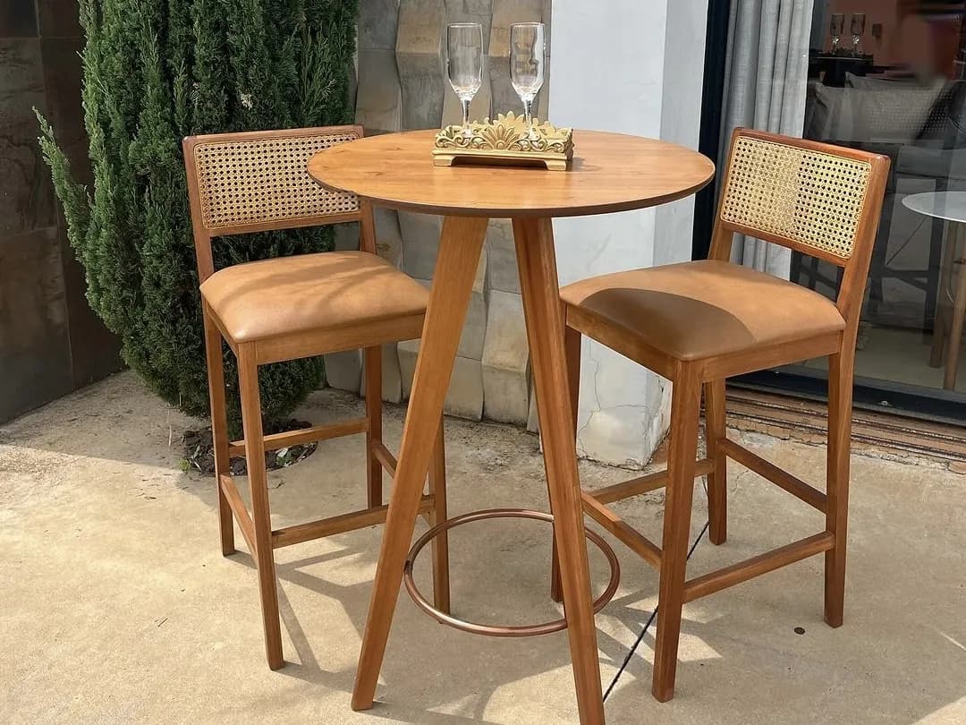 Mesa bistrô redonda de madeira com duas banquetas de encosto de palhinha e assento estofado caramelo