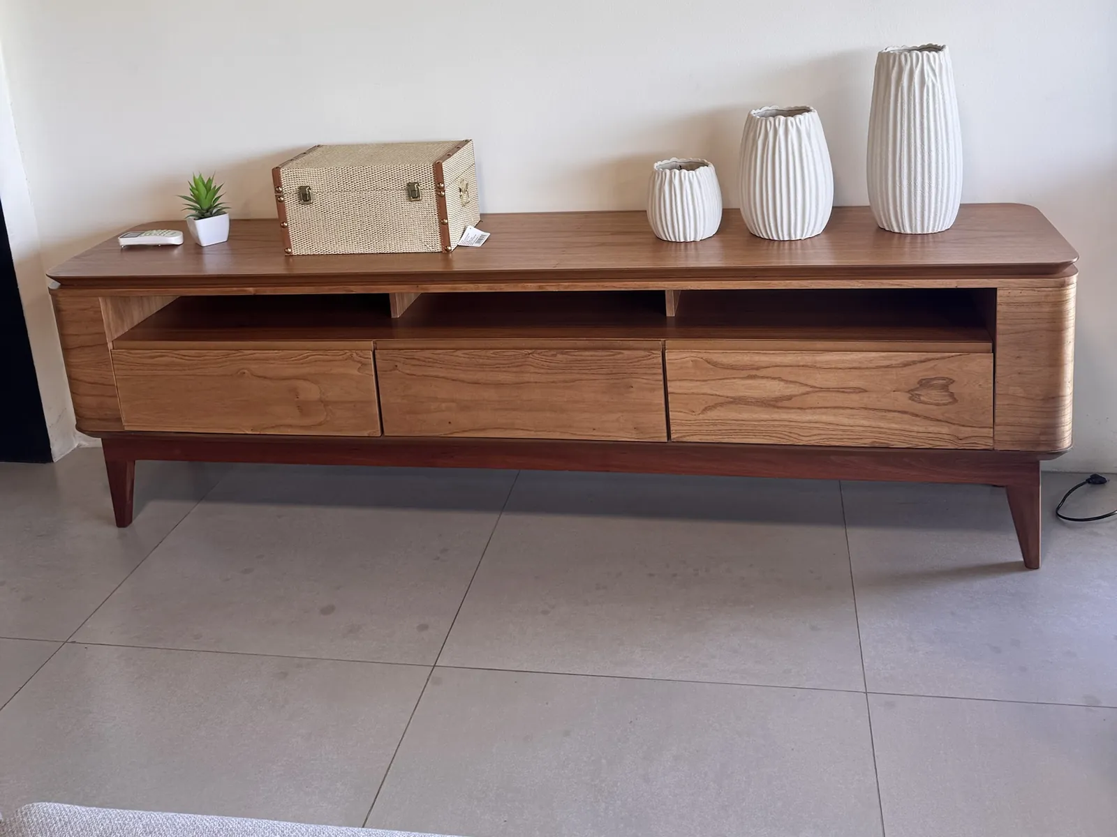Rack do Painel Mantiqueira, com três gavetas e pés de madeira, no showroom da Decorelar