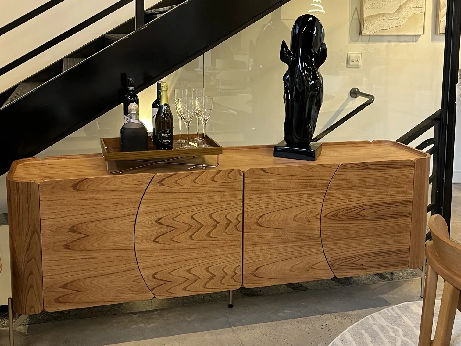 Buffet de madeira com quatro portas curvas no showroom da Decorelar